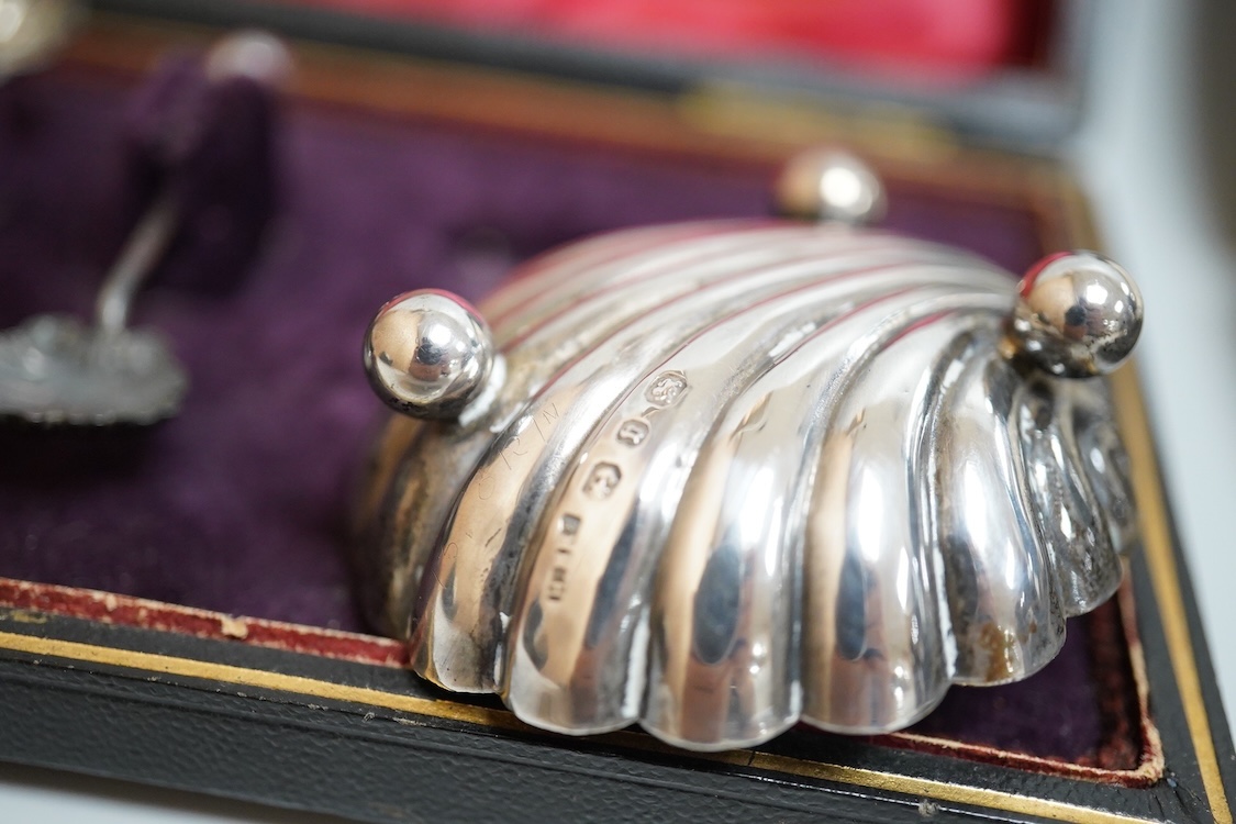 A cased pair of late Victorian silver shell salts on ball feet, with matching spoons, H. Bros, Birmingham, 1895, 46mm, together with a cased George V silver spoons and pusher and a Victorian silver shoe buckle (a.f.)